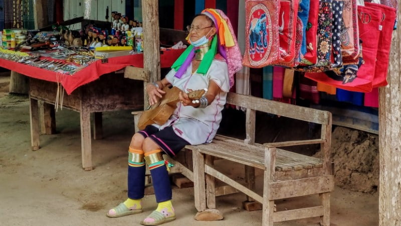 Longneck lady playing guitar at Ban Huai Sua Tao