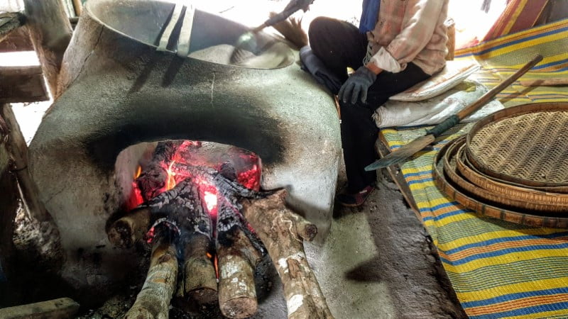 Roasting tiger peanuts with salt over wood fire in Mae Hong Son